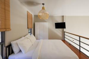 ein Schlafzimmer mit einem großen Bett und einer Hängeleuchte in der Unterkunft Aqua Luxe in Srithanu