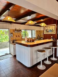 een keuken met een aanrecht en 2 krukken bij Okilei House in Taputapuapea