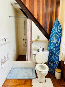 een badkamer met toilet en douche met surfplank bij Okilei House in Taputapuapea +17 foto's