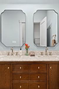 un bagno con due lavandini e due specchi di The Optimist Guesthouse | 2 a Camden