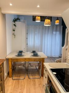 a kitchen with a table and two stools at Triplex Léonie - Standing and Comfort - 3 étoiles in Cluses +23 photos
