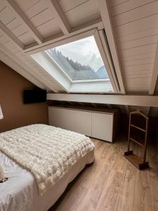 a bedroom with a bed and a large window at Triplex Léonie - Standing and Comfort - 3 étoiles in Cluses