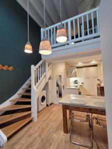 a kitchen and dining room with a staircase and a table at Triplex Léonie - Standing and Comfort - 3 étoiles in Cluses