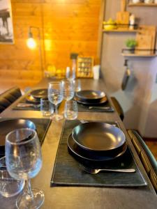 a table with plates and wine glasses on it at The Mountain Escape - Luxury Apartment in Prato Nevoso +13 photos