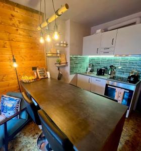 a kitchen with a large wooden table in a room at The Mountain Escape - Luxury Apartment in Prato Nevoso