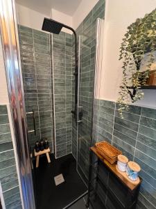 een douche in een badkamer met groene tegels bij Cosy Mountain Ski Escape Newly Renovated in Prato Nevoso