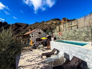 a patio with a swimming pool and a building at Casa Naranjo in Ayacata