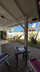 een patio met een hangmat en een tafel en stoelen bij Refúgio na Lagoa in Florianópolis