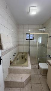 een badkamer met een bad, een toilet en een douche bij Refúgio na Lagoa in Florianópolis