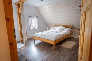een slaapkamer met een bed met een houten muur bij Jizerská roubenka in Bohdalovice