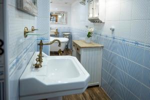 een badkamer met een witte wastafel en blauwe tegels bij Jizerská roubenka in Bohdalovice