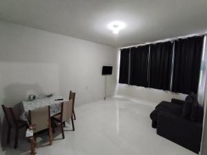 a living room with a table and chairs and a dining room at Apartamento na RETA de Teresópolis in Teresópolis