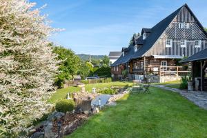 a large house with a garden in front of it at Jizerská roubenka in Bohdalovice