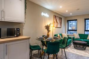 een keuken en een woonkamer met een tafel en groene stoelen bij Bright 2BR Flat, Central Chatham, Parking in Chatham