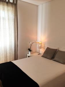sypialnia z białym łóżkiem i oknem w obiekcie LX Factory Apartment 1 w Lizbonie