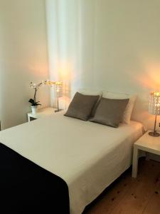 ein Schlafzimmer mit einem großen weißen Bett mit zwei Lampen in der Unterkunft LX Factory Apartment 1 in Lissabon
