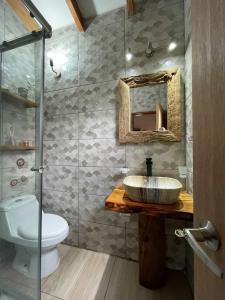 a bathroom with a sink and a toilet at Cabaña Rústica - Sector Pichares in Pichare