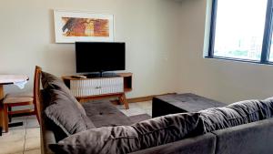 een woonkamer met een bank en een flatscreen-tv bij Flat Vista Pôr do Sol in Manaus +16 foto's