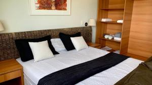 een slaapkamer met een groot bed met zwart-witte kussens bij Flat Vista Pôr do Sol in Manaus