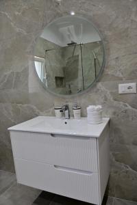 a bathroom with a white sink and a mirror at Ferienhaus Qelia in Durrës +28 photos
