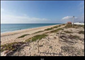 een leeg strand met de oceaan op de achtergrond bij Blife Mariangya private rooms at Faro beach in Faro