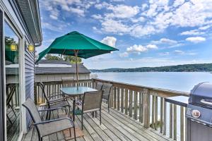 een terras met een tafel, stoelen en een parasol bij Spacious Lakefront House With a Private Dock in Hopatcong
