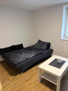 a black couch in a living room with a table at 2 Zimmer Ferienwohnung zu vermieten in Memmingen