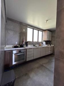 a kitchen with a sink and a stove at Apartamento Outeiro in Ilhéus