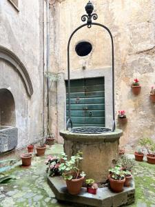 a courtyard with a fountain with potted plants in front of a building at DIMORA MedioEvo in Orvieto