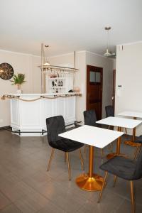 una sala da pranzo con tavoli bianchi e sedie nere di PLATINIUM House ex Royal House a Białogard