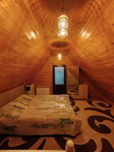 une chambre avec un grand lit dans une pièce en bois dans l'établissement Qusar A-Frame, à Qusar
