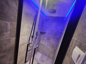 a bathroom with a shower with blue lights at No1 - Flo's modern Rooms & Breakfast in Wagrain +44 photos