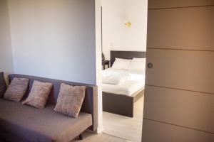 un salon avec un canapé et un lit dans l'établissement Charmant studio 2 pièces entièrement équipé,, à Chenac-sur-Gironde