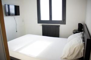 une chambre avec un lit blanc et une télévision dans l'établissement Charmant studio 2 pièces entièrement équipé,, à Chenac-sur-Gironde