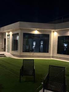 twee stoelen voor een huis 's nachts bij شاليهات ايفا in Taif