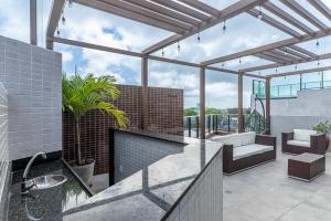a balcony with a sink and a living room at Season Smart Flat Ipojuca in Porto De Galinhas