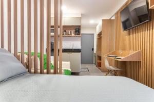 a bedroom with a bed and a desk and a kitchen at Season Smart Flat Ipojuca in Porto De Galinhas +9 photos