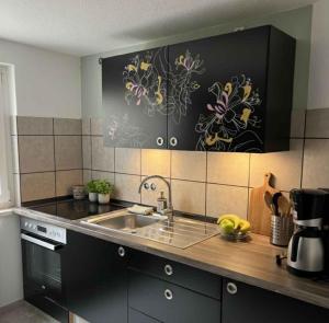 eine Küche mit Spüle und Theke in der Unterkunft Wellness -Residenz Ehrhardt Urlaub mit Pool und Garten Ferienwohnung in Halberstadt in Halberstadt