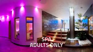 a purple room with stairs and a sign that says spa adults only at Hotel La Maison Wellness & Spa in Alleghe