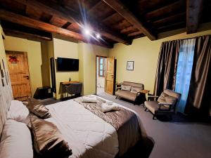 a bedroom with a large bed and two chairs at IL MOLINO del SIGNORE in Pergola