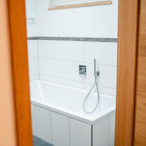 ein Bad mit einer Dusche an einer weiß gefliesten Wand in der Unterkunft janzweitnah in Gerolstein + 32 Fotos