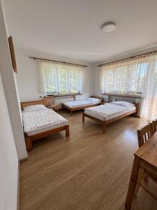 ein Zimmer mit drei Betten und Fenstern in der Unterkunft Kajakiem z Marzysza in Marzysz