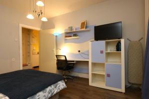 a bedroom with a bed and a desk with a television at DARA Apatman in Šabac