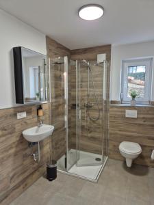 un bagno con doccia, lavandino e WC di Ferienwohnung - ZeitRaum a Gemünden