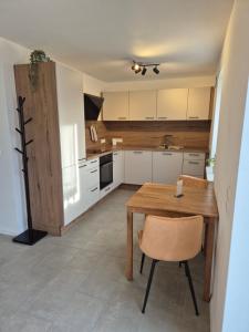 una cucina con un tavolo di legno e una sedia di Ferienwohnung - ZeitRaum a Gemünden