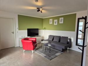 un soggiorno con un divano e una sedia rossa di Ferienwohnung - ZeitRaum a Gemünden