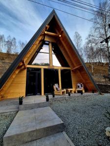 een hut met een driehoekig dak en een groot raam bij Amurg in Lupeni