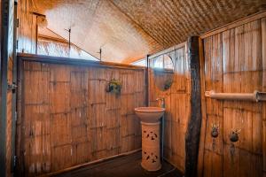 a bathroom with a toilet in a wooden wall at Lazy mango homestay in Ban Mae Sapok Nua