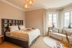 ein Schlafzimmer mit einem Bett und einer Couch in der Unterkunft Villa Vulkaneifel in Kelberg