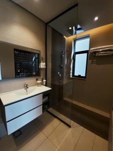 een badkamer met een wastafel en een douche bij شاليهات ايفا in Taif